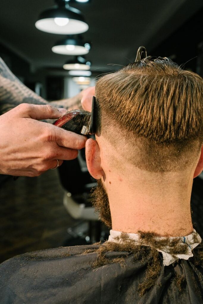 pexels-photo-4625626 Barber performing a stylish haircut on a man in a modern barbershop.